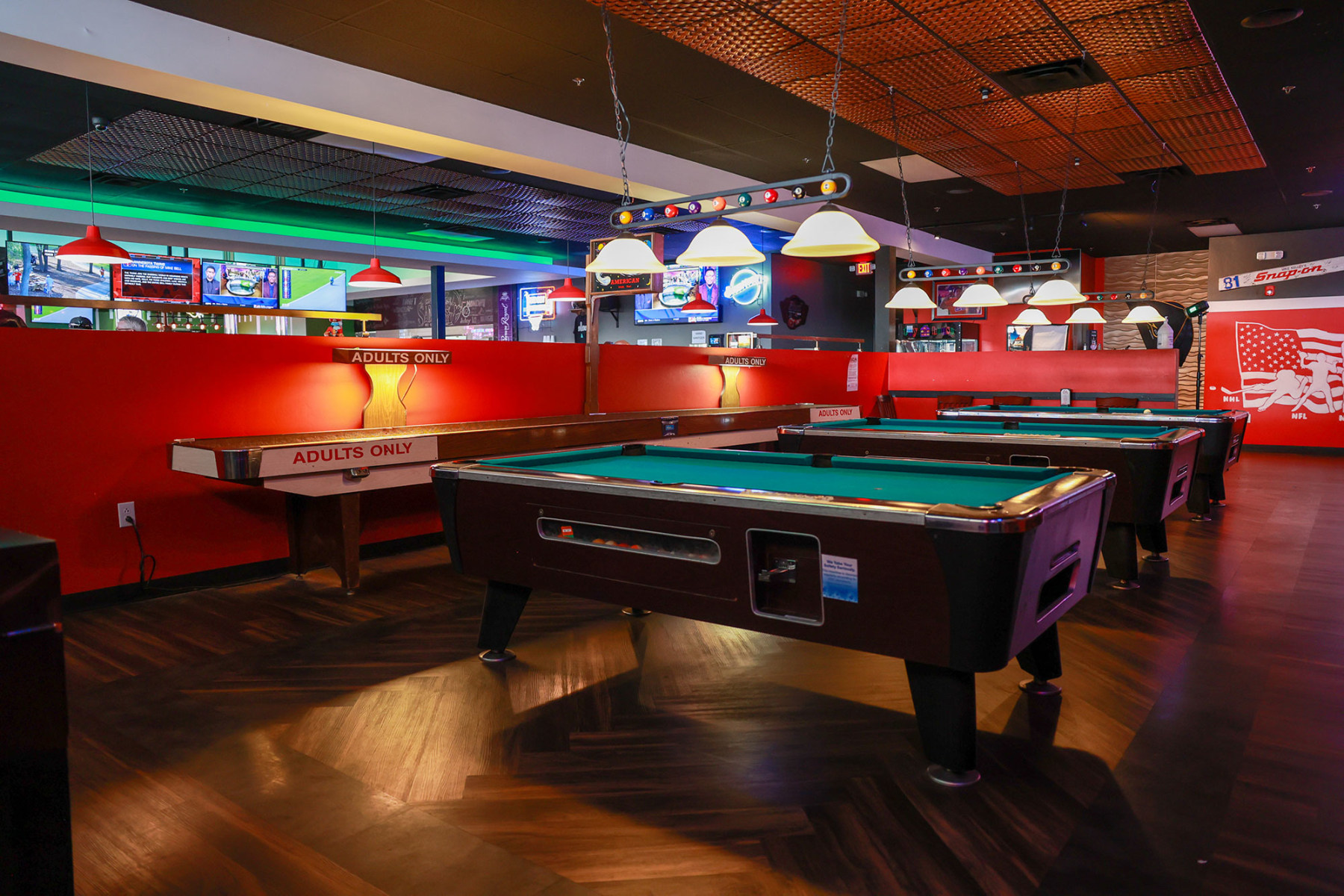 Pool tables and sports screens inside Famous Sam’s on River